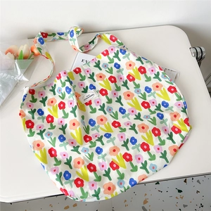 Detailed close-up of a floral oil painting canvas tote bag with a woven brand label