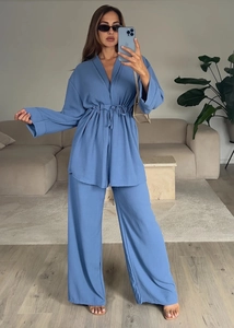 Detail of blue long-sleeved tie-waist top and wide-leg trousers set with textured fabric