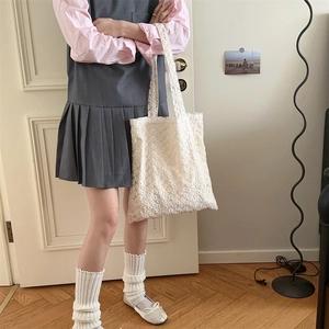 Detail of the white lace floral tote bag featuring intricate hollow out mesh crochet pattern
