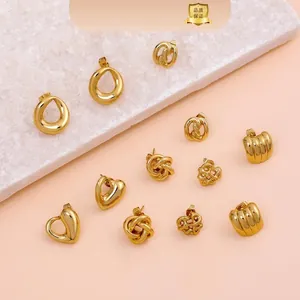 Collection of geometric gold-plated stud earrings in various shapes on marble display