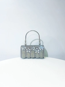 Close-up of silver rhinestone evening bag featuring luxury crystal fringe and metal handle
