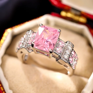 Detailed view of square pink gemstone ring with micro-pave setting in red jewelry box