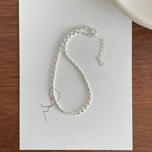 Detail of S925 sterling silver olive bead chain with lobster clasp on artistic card