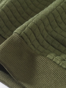 Macro view of olive green waffle knit fabric showing premium texture and ribbed cuff