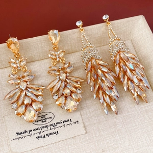 Détail de boucles d'oreilles vintage avec strass ambrés et pampilles dorées