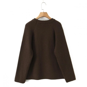 Close-up of dark brown ribbed knit long sleeve sweater texture on wooden hanger