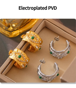 Detail von PVD-beschichteten Ohrringen mit strukturierter Oberfläche und grünem Edelstein