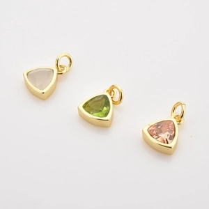 Macro view of three colorful triangular gemstone pendants with gold plated settings