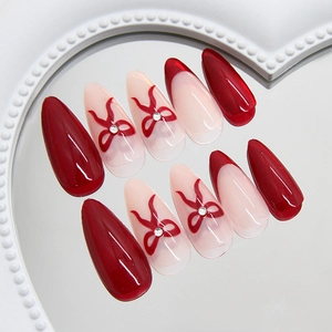 Sparkling burgundy cat-eye press-on nails with 3D bow and rhinestone accents