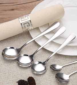 Detailed set of polished stainless steel round spoons in two sizes on an elegant table