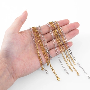 Hand holding gold and silver stainless steel paperclip chains with lobster clasps