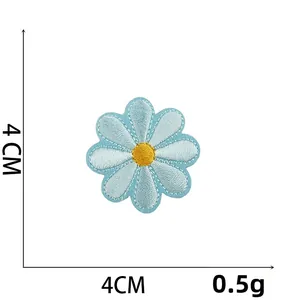 Detail view of a 4cm light blue daisy embroidered patch with yellow center and stitching