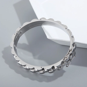 Gros plan d'un bracelet gourmette en acier inoxydable argenté avec texture ondulée et fermoir