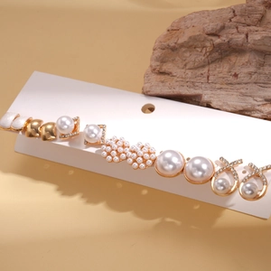 Detail view of 12-piece pearl and rhinestone earring set on a white display card