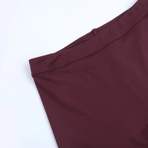 Detailed view of the burgundy yoga shorts featuring high waist stitching and elastic fabric