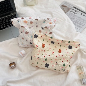 Detailed close-up of quilted cosmetic bags with cartoon dog and Christmas bear patterns