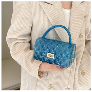 Close-up of blue jelly bag featuring quilted patterns, beaded handle and gold twist lock