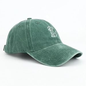 Detailed close-up of cartoon dog embroidery on washed green cotton baseball cap