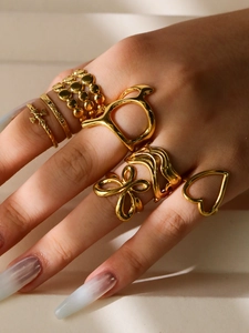 Macro detail of gold-plated rings set featuring镂空 'D' letter and heart motifs