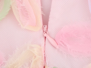 Macro detail of the invisible pink zipper on high-waist mesh dress with 3D floral fringe