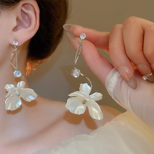 Gros plan sur les boucles d'oreilles fleurs à pampilles en perles et zircons argentés