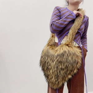 Detail of a large heart-shaped crossbody bag in fluffy brown faux raccoon fur texture