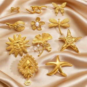 Golden stainless steel brooches collection with butterfly and floral motifs on satin