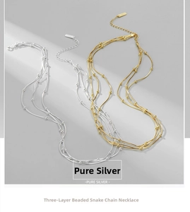 Detail of S925 sterling silver three-layer snake chain necklace with golden beads