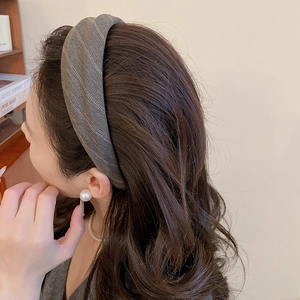 Side view of woman wearing a grey herringbone fabric headband with a thick textured design