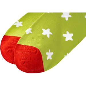 Detail of green knit Christmas socks with red toe and white star patterns on cotton fabric