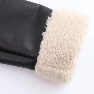 Close-up of black leather coat sleeve with thick beige faux fur lining and texture details