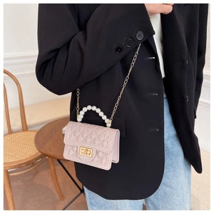 Pink quilted silicone mini bag with pearl handle and chain strap worn by a model