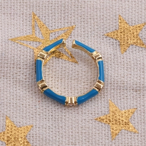 Detail of adjustable bamboo style ring with blue enamel and gold finish and small rhinestones