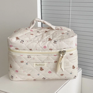 Detail of quilted donut bear makeup bag with dual zippers and ribbon pullers