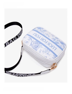 Detail of white crossbody bag with blue floral print and LUCK FOR YOU text on front