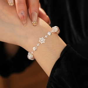 Détail macro de maillons floraux en argent avec zircons et perles blanches élégantes