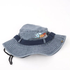 Detail of blue denim kids bucket hat with colorful train embroidery and windproof cord