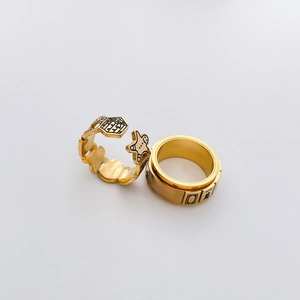 Detail of gold rings featuring gingerbread man house and mahjong characters design