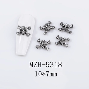 Macro detail of skull-shaped alloy nail charms with rhinestones measuring 10x7mm