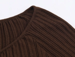 Detailed close-up of dark brown ribbed knit fabric texture and shoulder stitching detail