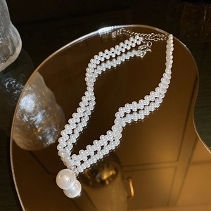 Detailed view of elegant double-layered pearl necklace with a large spherical pearl pendant