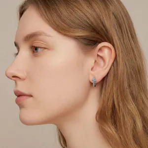 S925 sterling silver cross hoop earrings with blue zircon stones worn by a model