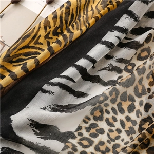Macro detail of mixed leopard and zebra animal print scarf with soft fringe texture