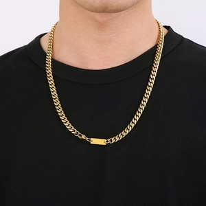 Close-up of a gold Cuban link necklace with rectangular pendant worn by a model