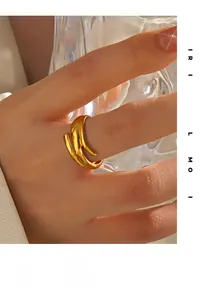 Anello a spirale dorato lucido sulla mano con moderna finitura a specchio minimalista