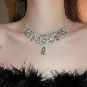 Detail shot of sparkling rhinestone water drop fringe necklace on model neckline