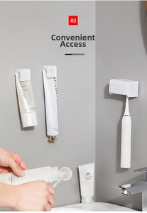 Detailed view of three wall-mounted adhesive holders for toothpaste and electric toothbrushes