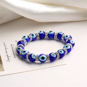 Detail of blue evil eye beads bracelet with silver sparkling crystal spacers on silk