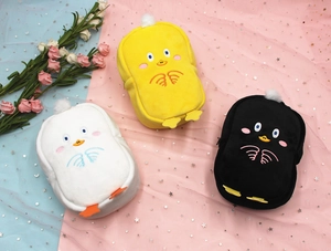 Detailed view of plush cartoon bird pouches in yellow, white, and black colors