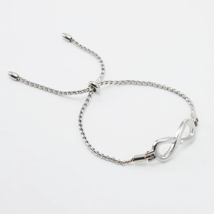 Macro detail of silver infinity symbol on a minimalist adjustable twist rope chain bracelet